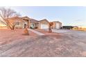 View of the home with a two-car garage and a separate storage building at 1464 Barlow Ave, Moapa, NV 89025