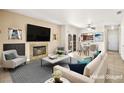 Bright, staged living room with fireplace, tile floors, and sliding glass doors to outdoor space at 1851 Hillpointe Rd # 2922, Henderson, NV 89074