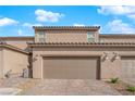 Exterior of townhome showcasing two-car garage and outdoor lighting at 2607 Aversa St, Henderson, NV 89044