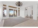 Bright living room featuring sliding doors to a covered patio with mountain views and elegant light fixture at 379 Turquoise Ct, Boulder City, NV 89005