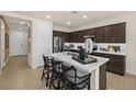 Modern kitchen with a large white countertop island, dark cabinets, stainless steel appliances, and pendant lighting at 4220 E Brusca Way, Pahrump, NV 89061