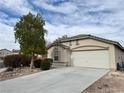 Single-story home featuring a spacious driveway and a two-car garage on a sunny day at 4928 Indigo Gorge Ave, Las Vegas, NV 89131