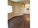 Open-concept living room with laminate flooring, a bright window, and attached kitchen area at 5250 S Rainbow Blvd # 1121, Las Vegas, NV 89118