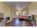 Cozy living room with a decorative fireplace, wood flooring, and lots of natural light at 5250 S Rainbow Blvd # 1121, Las Vegas, NV 89118