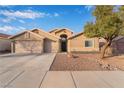 Charming single-story home featuring a three-car garage and desert landscaping at 58 Desert Sunflower Cir, Henderson, NV 89002