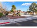 Beautiful single-story home with a tile roof, desert landscaping, and mature palm trees at 60 Reyburn Dr, Henderson, NV 89074