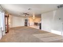 Open-concept living room with neutral carpet, ceiling fan, and views of the dining area at 6240 Clarice Ave, Las Vegas, NV 89107