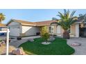 Single-story home with desert landscaping and green lawn with palm tree at 6717 Atwood Ave, Las Vegas, NV 89108