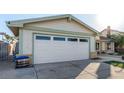 Two car garage with white door and light green trim with a paved driveway at 6717 Atwood Ave, Las Vegas, NV 89108