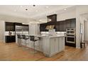 A spacious kitchen featuring black cabinets, pendant lighting, and a large center island at 733 Aberdeen Tartan St, Las Vegas, NV 89138