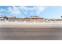 Single story house with a charming white fence and a backdrop of clear blue sky at 845 Palo Verde Dr, Henderson, NV 89015