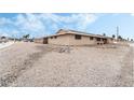 Side view of a single story home with a gravel yard and classic architecture under a partly cloudy blue sky at 845 Palo Verde Dr, Henderson, NV 89015