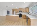 Modern kitchen featuring an island, stainless steel appliances, new cabinets, and stylish countertops at 865 Armada Pl, Boulder City, NV 89005