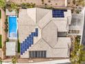 Aerial view of a home's rooftop solar panels, private pool, patio area, and desert landscaping at 11110 Mount Cass St, Las Vegas, NV 89141