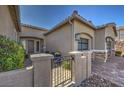 Close up of the home's entrance and three-car garage, featuring desert landscaping at 11110 Mount Cass St, Las Vegas, NV 89141