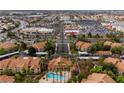 An aerial view showcases the community pool, lush landscaping, nearby shopping centers, and overall neighborhood layout at 2300 E Silverado Ranch Blvd # 2040, Las Vegas, NV 89183