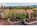 Exterior building view showcases well-maintained landscaping, mature trees, and ample parking at 2300 E Silverado Ranch Blvd # 2040, Las Vegas, NV 89183