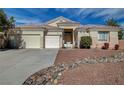 Lovely single-story home boasts a three-car garage and desert landscaping for easy upkeep at 344 E Rush Ave, Las Vegas, NV 89183