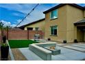 This backyard features an outdoor seating area with a built in fire pit and artificial turf at 5705 Petrified Tree Ln, North Las Vegas, NV 89081
