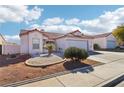 Charming single-story home with a red tile roof, desert landscaping and a two car garage at 613 Craig Creek Ave, North Las Vegas, NV 89032