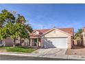 Single-story home featuring a 2-car garage, tile roof, mature tree, well-maintained lawn, and desert landscaping at 7021 Feather Pine St, Las Vegas, NV 89131