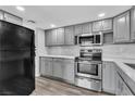 Bright kitchen features gray cabinetry, stone countertops, stainless steel appliances, and wood floors at 808 N Torrey Pines Dr, Las Vegas, NV 89107