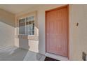 View of the home's entryway, showcasing the front door, sidelight window, and neutral exterior at 9304 Cranesbill Ct, Las Vegas, NV 89149