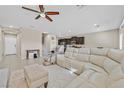 Open living room and kitchen area with tile flooring, an area rug, and a white leather sectional at 9413 Aggie Ct, Las Vegas, NV 89148