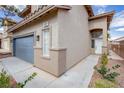 Exterior view of a two-story home featuring desert landscaping, a two-car garage, and a white front door at 9882 Pioneer Ave, Las Vegas, NV 89117