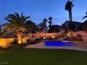 Backyard oasis with a large pool, water features, slide and lush landscaping at 1705 Pink Cliff Ct, Las Vegas, NV 89128
