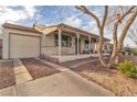 Single-story home with a large covered porch, garage, and low-maintenance landscaping at 239 N Bruce St, Las Vegas, NV 89101