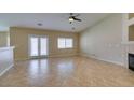 A spacious living room with tile floors, neutral paint, large windows and french doors to the outside at 3412 Amish Ave, North Las Vegas, NV 89031