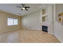 A cozy living room features a fireplace, tile floors, neutral paint, and a ceiling fan at 3412 Amish Ave, North Las Vegas, NV 89031