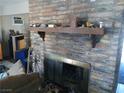 Living area showcasing a brick fireplace and hearth with wooden mantelpiece at 4200 Coran Ln, Las Vegas, NV 89108