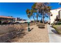 A community dog park area with gravel, landscaping, and pet waste station at 5015 Spencer St # C, Las Vegas, NV 89119