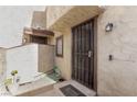 Front entryway with a secure iron gate, tiled steps, and beige stucco exterior at 5015 Spencer St # C, Las Vegas, NV 89119