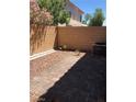Fully fenced private backyard featuring a brick patio, gravel landscaping, and an AC unit at 5392 Blustery Towns Ave, Las Vegas, NV 89118
