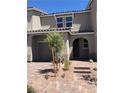 Exterior front view of a home with a two-car garage and landscaping at 5392 Blustery Towns Ave, Las Vegas, NV 89118