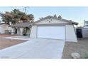 Single-story home featuring a two-car garage and a large driveway at 5773 Arbor Oak Cir, Las Vegas, NV 89142