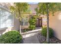 Inviting front entrance with a walkway framed by lush landscaping and ornamental trees at 8225 Taos Paseo Ave, Las Vegas, NV 89128
