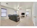 Spacious living room with neutral tile floors, ceiling fan and dark leather sofa set at 9563 Grapeland Ave, Las Vegas, NV 89148