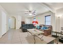Open living room with neutral tile floors, bright walls, stairs, and comfortable leather sofa set at 9563 Grapeland Ave, Las Vegas, NV 89148