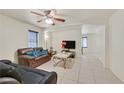 Cozy living room features neutral tile floors, bright walls, ceiling fan and comfortable seating at 9563 Grapeland Ave, Las Vegas, NV 89148