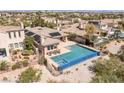 A luxurious desert home features a sparkling pool with integrated spa and solar panels for energy efficiency at 11473 Glowing Sunset Ln, Las Vegas, NV 89135