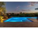 Dusk view of private pool with inviting lights and landscaping at 11473 Glowing Sunset Ln, Las Vegas, NV 89135