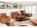 A living room featuring an area rug, neutral paint, and three windows at 2080 Karen Ave # 21, Las Vegas, NV 89169