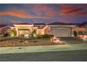 Attractive front exterior view of a single-story home featuring desert landscaping and warm lighting at 2720 Spalding Dr, Las Vegas, NV 89134