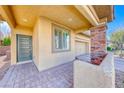Home exterior showcasing the entry door, brick pillar, and paved driveway leading to the garage at 3049 Echoed Rondel Ln, Henderson, NV 89044