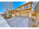 Inviting two-story home with a brick-accented porch, neutral color scheme, and a paved driveway at 3049 Echoed Rondel Ln, Henderson, NV 89044