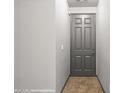 View of a light, bright hallway featuring tile floors and a gray, paneled front door at 344 Tuscany Cir, Mesquite, NV 89027